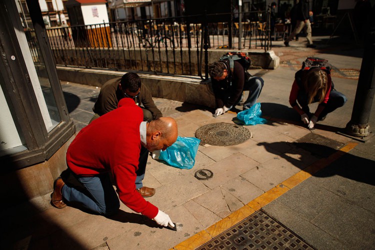 Concejales y voluntarios participan en una retirada de chicles en la vía pública