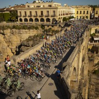 El pelotón de ciclistas a su paso por plaza de España y Puente Nuevo.