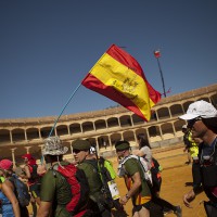 Un grupo de deportistas cruzando el ruedo de la plaza de toros de Ronda.