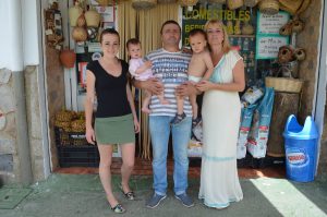 La familia que regenta el negocio en la puerta de la tienda.