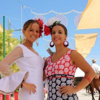 Dos jóvenes vestidas de flamenco disfrutando de la Feria de Ronda.