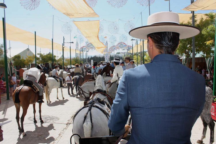 Caballistas y peñistas animan el Real en el Jueves de Feria y el Centro se queda casi solo