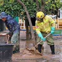 Un vecino y un bombero forestal del Infoca retiran lodo en las calles de Jimera de Líbar.