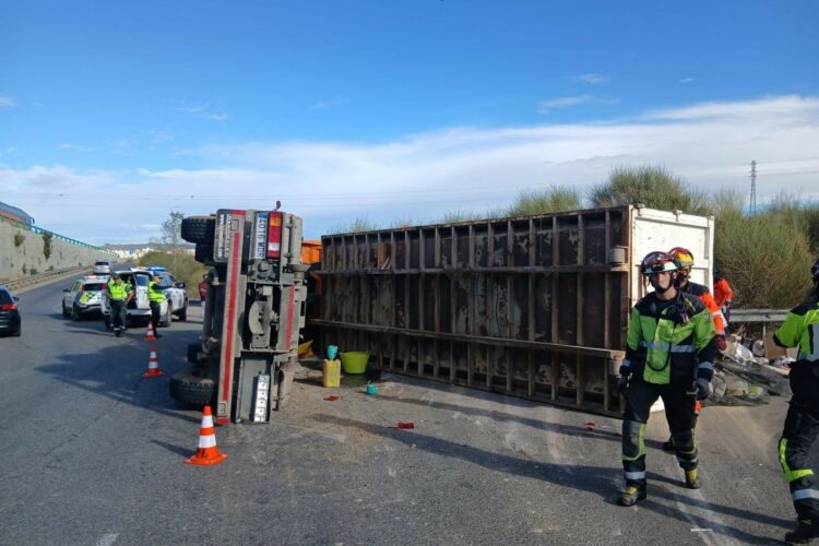 Un camión vuelca en una rotonda de entrada a la ciudad al descompensarse la carga de residuos que transportaba